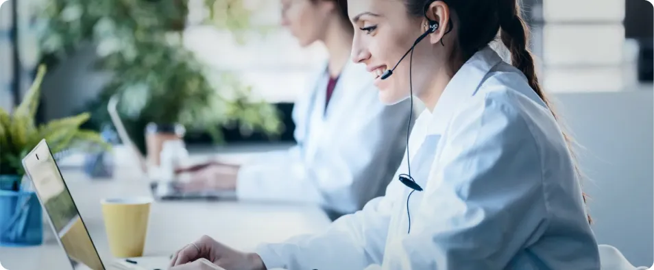 Mujer joven sociosanitaria en contact center hablando con una persona mayor.