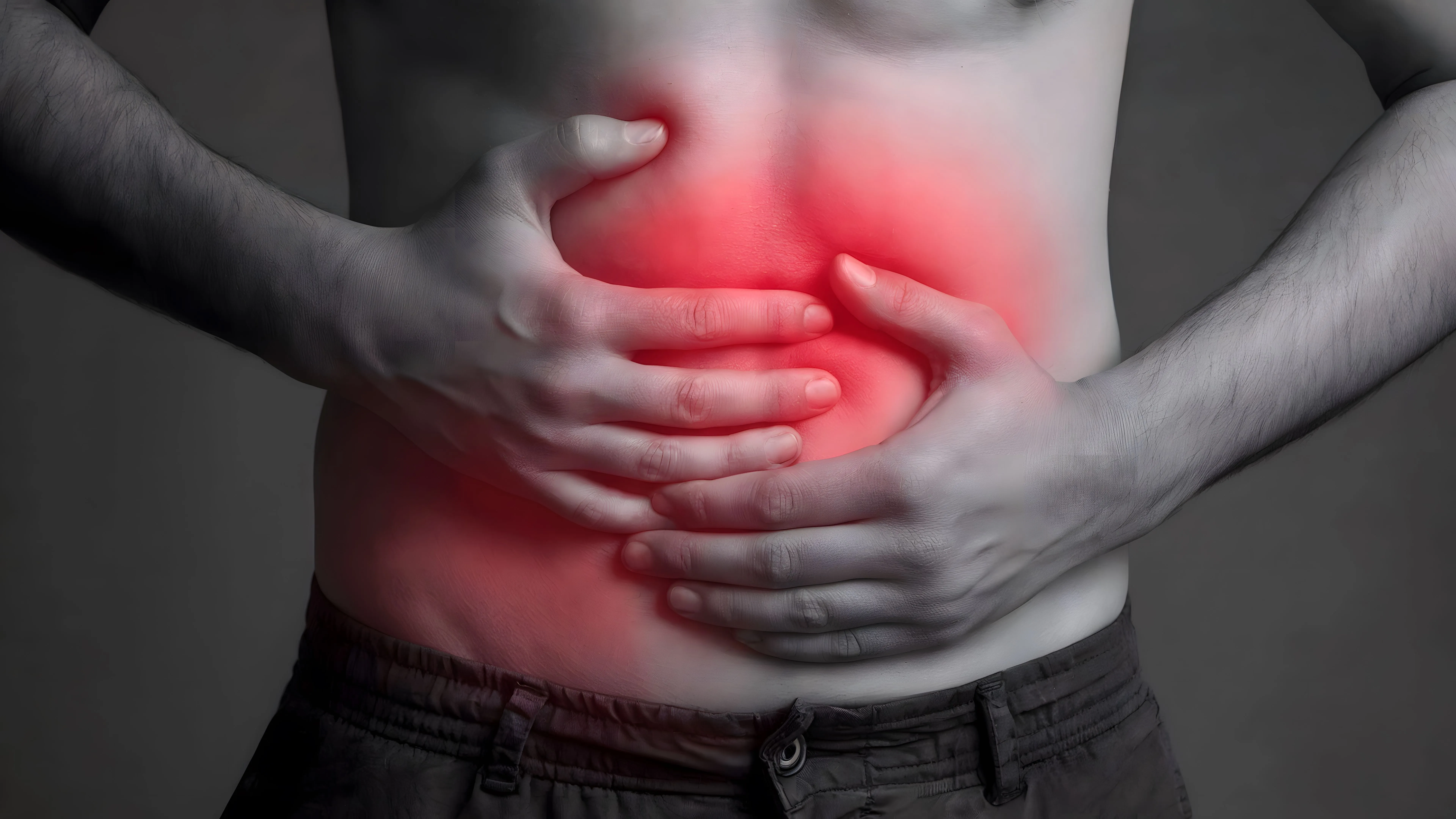 Imagen hombre tacándose el abdomen con mucho dolor.