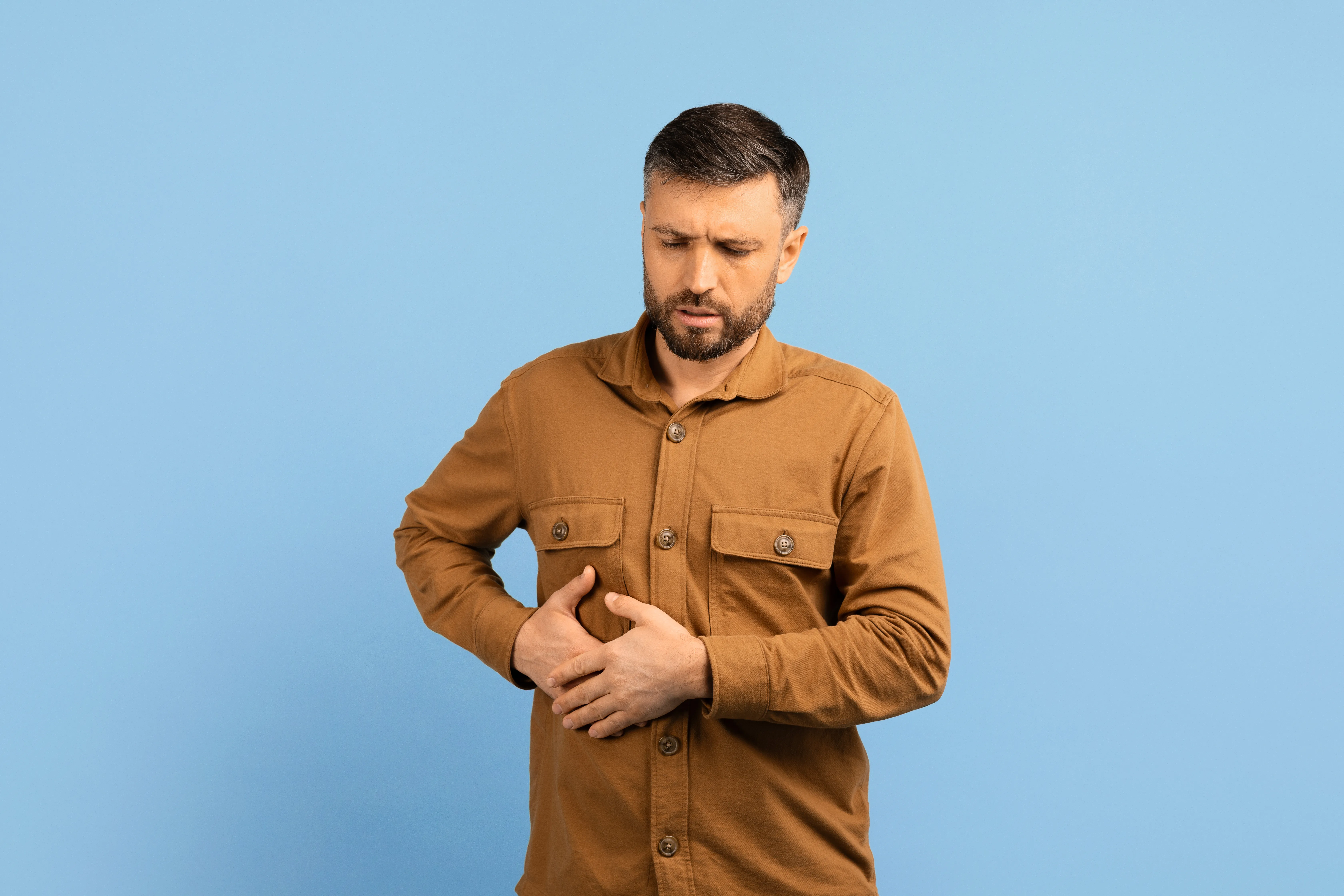 Hombre con barba tacándose las costillas.