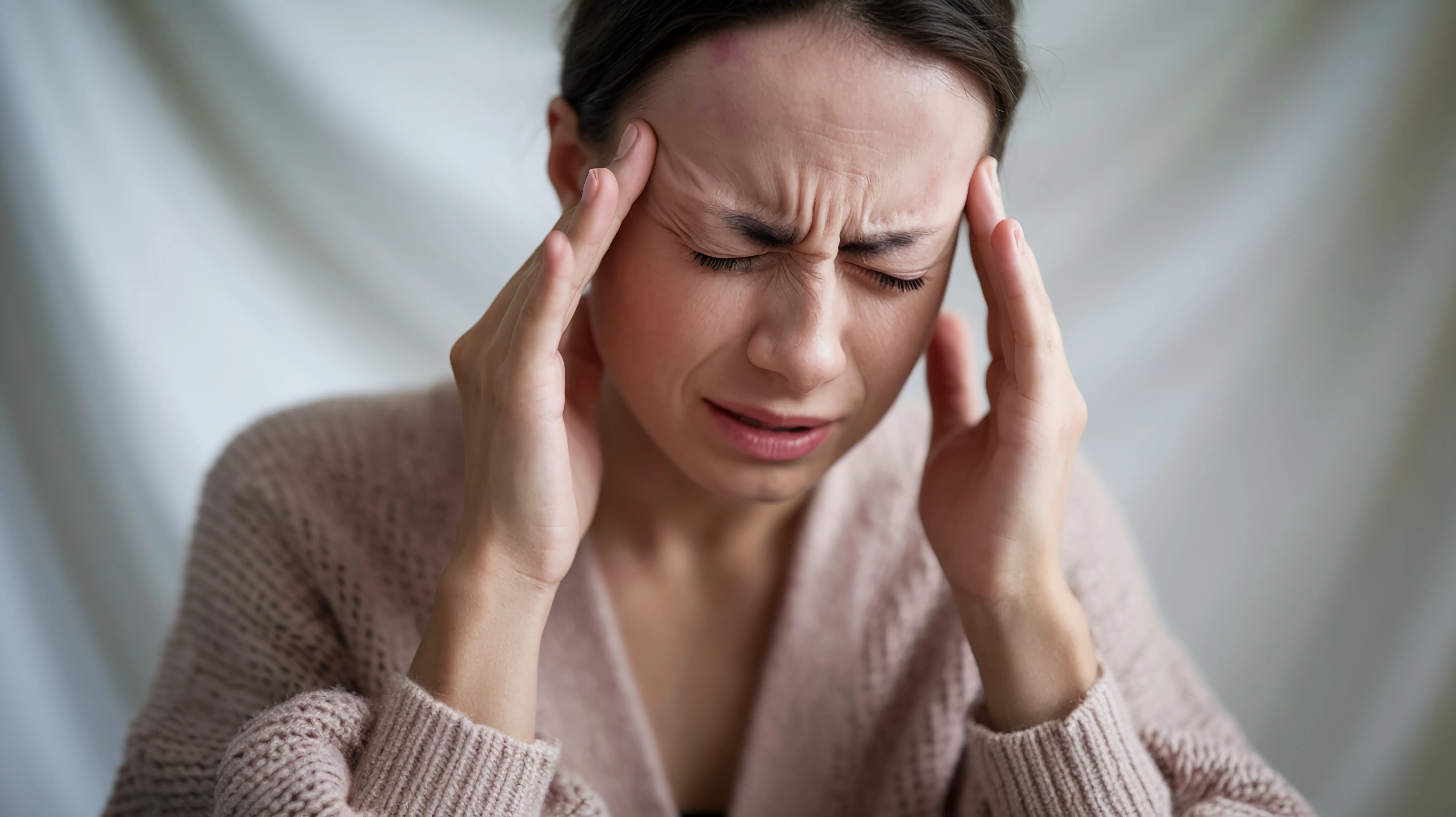 Mujer con fuertes dolores de cabeza.
